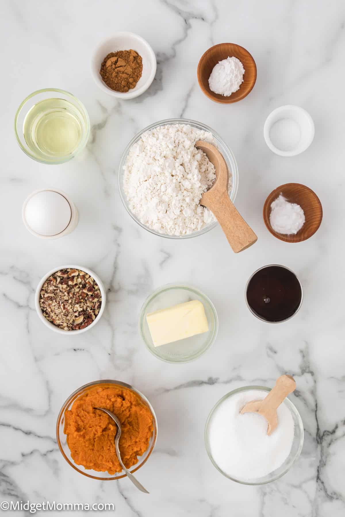 umpkin Bread with Pecan Maple Streusel Topping ingredients -  Top-down view of baking ingredients on a marble surface, including flour, sugar, butter, pumpkin puree, pecans, oil, molasses, and various spices, all placed in bowls and cups.