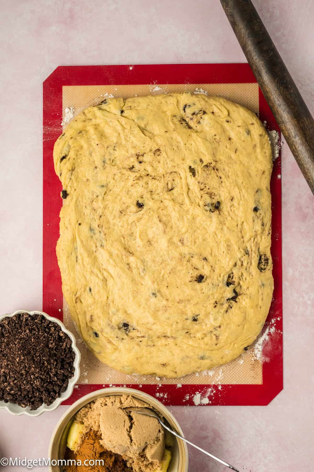 Oreo Cinnamon Rolls dough rolled out on a baking mat.